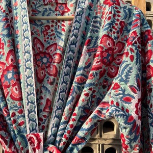 May include: A blue and red floral print cotton robe with a tie closure. The robe has a traditional Japanese kimono style.