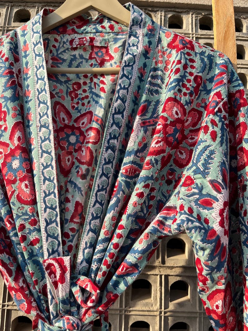 May include: A blue and red floral print cotton robe with a tie closure. The robe has a traditional Japanese kimono style.