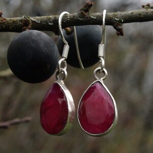 Puede incluir: Un par de pendientes de plata con piedras preciosas rosas en forma de lágrima.