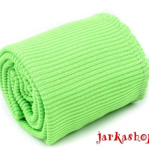 May include: A bright green ribbed knit fabric rolled up. The fabric is soft and stretchy.