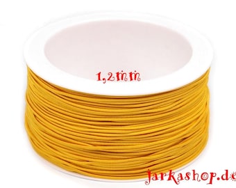May include: A spool of bright yellow elastic cord, 1.2 inches in diameter. The cord is wound tightly around a white plastic spool.