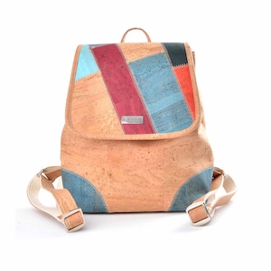 May include: A cork backpack with a patchwork design featuring blue, red, and orange squares. The backpack has a flap closure and adjustable straps.