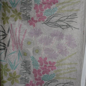 May include: Floral fabric with a pattern of pink, lavender, green, and teal botanical designs on a light grey background. The design includes flowers, leaves, and other plant elements, creating a nature-inspired aesthetic.