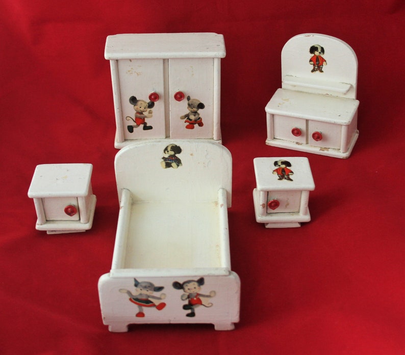 May include: A white wooden dollhouse furniture set with a bed, dresser, wardrobe, and two bedside tables. The furniture is decorated with cartoon characters, including Mickey Mouse and Pluto.