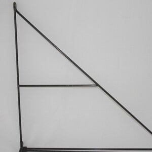 Könnte beinhalten: Schwarze Metall-Regalhalterung mit dreieckiger Form und zwei horizontalen Balken.