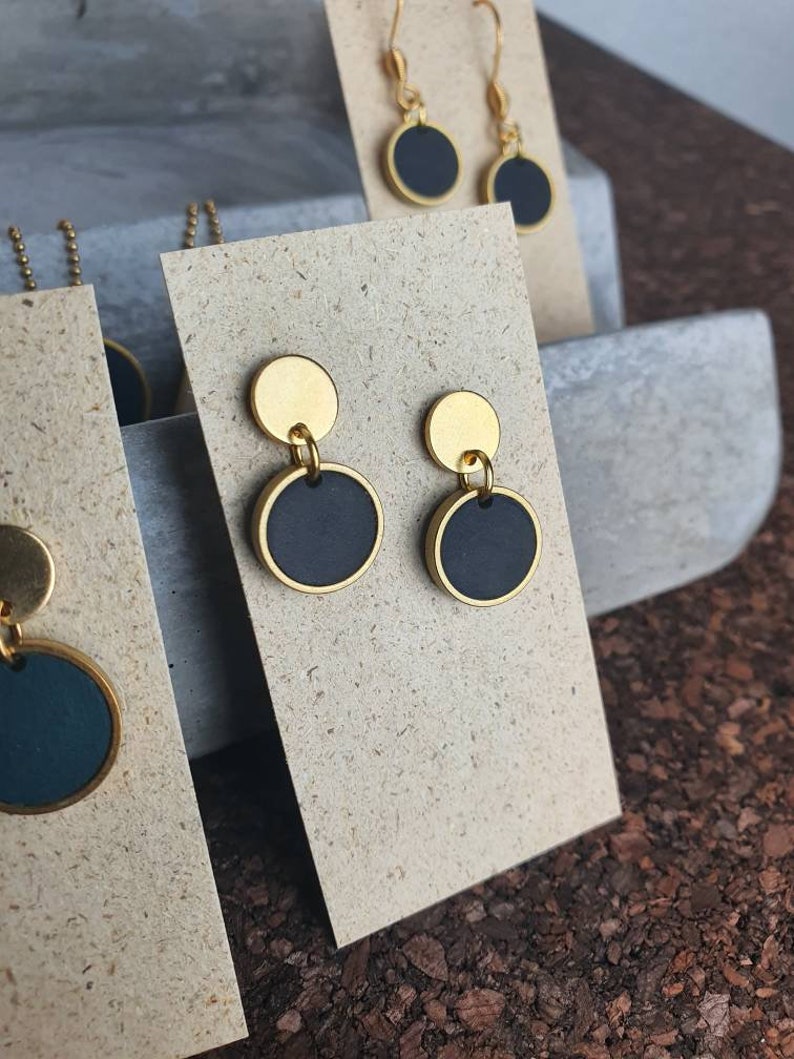 ohrringe mit stecker aus edelstahl, goldfarben, schwarzer runder anhänger mit goldfarbenem rahmen, messing