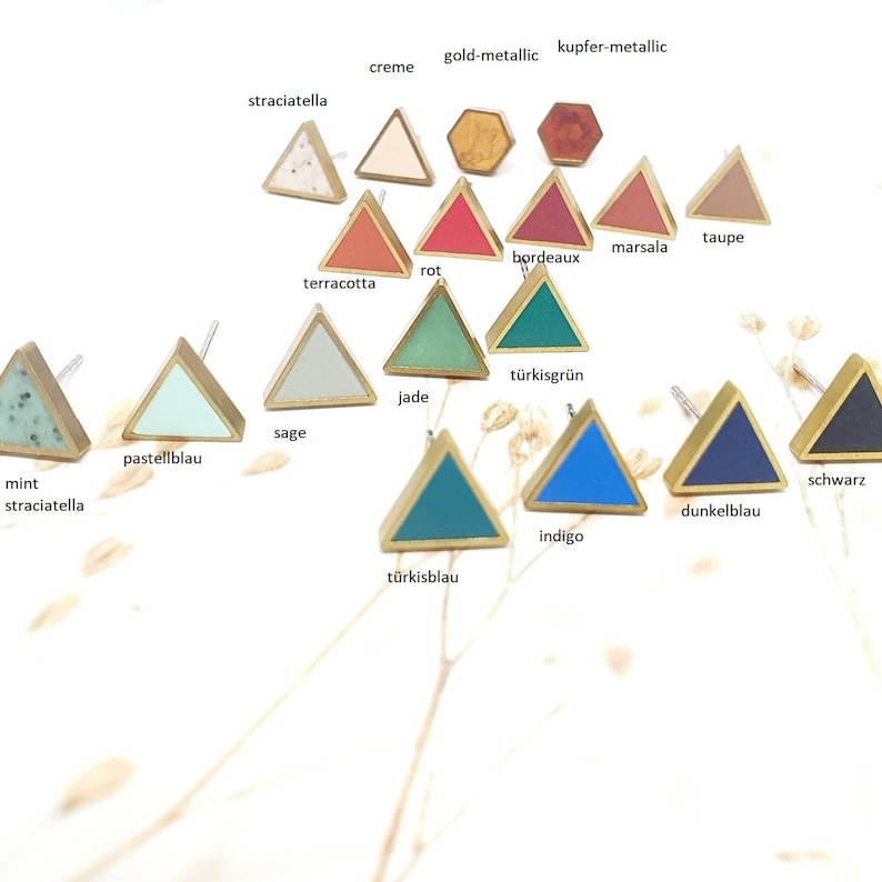 Puede incluir: Una variedad de pendientes en forma de tri&aacute;ngulo con incrustaciones de resina de diferentes colores. Los colores incluyen menta, salvia, jade, turquesa, &iacute;ndigo, azul oscuro, negro, terracota, rojo, burdeos, marsala, topo, crema y oro. Los pendientes est&aacute;n hechos de lat&oacute;n.