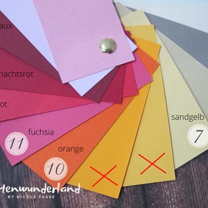 May include: A color chart with 11 different shades of red, orange, and yellow. The colors are labeled with German words, including "Bordeaux", "Weihnachtsrot", "Rot", "Fuchsia", "Orange", and "Sandgelb". The numbers 7, 10, and 11 are circled on the chart.