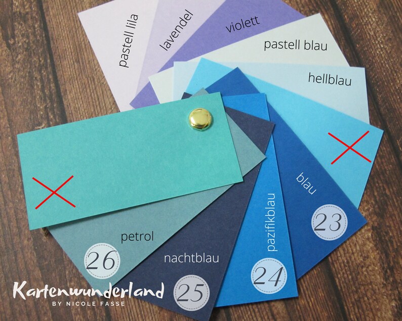 May include: A color chart with 10 different shades of blue, from light blue to dark blue. The chart is labeled with the German names for each color, including "pastell blau", "hellblau", "blau", "pazifikblau", "nachtblau", "petrol", "lavendel", "violett", and "pastell lila". The chart also includes numbers 23, 24, 25, and 26.