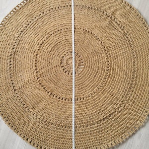 Puede incluir: Una alfombra redonda de yute en tono natural, con dise&ntilde;o de c&iacute;rculos conc&eacute;ntricos. Una cinta m&eacute;trica indica un di&aacute;metro de aproximadamente 152 cm. La alfombra tiene una superficie texturizada y un borde decorativo.