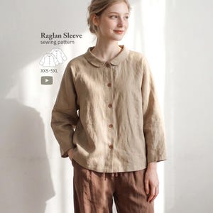 May include: A beige long-sleeve button-down shirt with a rounded collar and raglan sleeves. Text on the image reads: Raglan Sleeve sewing pattern, XXS-5XL. The shirt features a front button placket and a loose fit, shown in a neutral tone.