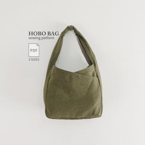 May include: An olive green hobo bag with a single shoulder strap and a black and white striped interior lining. The text HOBO BAG sewing pattern, PDF, and 2 SIZES is printed in black to the left of the bag against a plain white background.