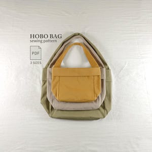 Pode incluir: Um molde de costura digital para uma bolsa hobo, com o texto HOBO BAG sewing pattern, PDF e 3 SIZES. A imagem mostra três bolsas hobo encaixadas nas cores amarelo mostarda, bege claro e verde oliva, cada uma com uma alça de ombro única.