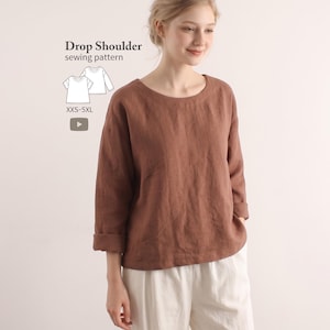 May include: A brown long-sleeve top with a round neckline and drop shoulders. The text Drop Shoulder sewing pattern XXS-5XL is visible, along with a line drawing of the garment. The top has cuffed sleeves and a loose fit.