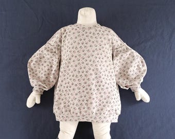 May include: A long-sleeve sweatshirt in a light beige fabric featuring a small-scale floral pattern in shades of pink and green. The garment has a crew neckline, a ribbed hem, and voluminous puff sleeves with ribbed cuffs.
