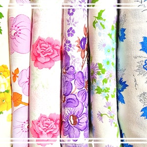 Könnte beinhalten: Fünf Stoffmuster mit Blumenmustern. Die Muster sind weiß mit verschiedenen farbigen Blumen. Die Blumen sind rosa, lila, blau und gelb.