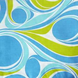 Op de afbeelding: Abstracte stof met een draaiende print in tinten blauw, groen en wit.