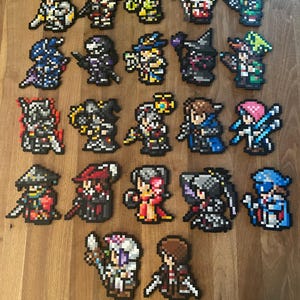 May include: A collection of 25 colourful pixel art characters, each with unique designs and details. The characters are made of small square beads and are arranged in rows on a wooden surface.