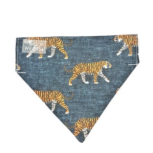 May include: A blue bandana with a white "my WOOF WEARS" label and a repeating pattern of orange and black tigers.