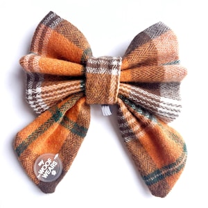 Può includere: Fazzoletto a farfalla a quadri arancio, marrone e verde con un'etichetta bianca che dice "My Woof Wears".