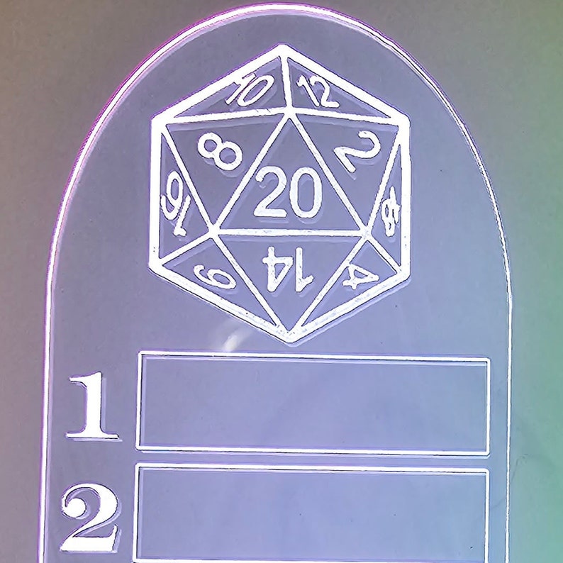 Może przedstawiać: Biały stojak akrylowy z wzorem 20-ściennej kostki do gry na g&oacute;rze. Stojak ma dwa puste miejsca oznaczone numerami 1 i 2.