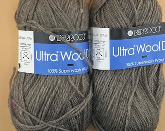 May include: Two skeins of Berroco Ultra Wool Dk yarn in a muted gray color. Each skein has a blue label with the Berroco logo and product information. The yarn is 100% Superwash Wool and is suitable for knitting projects.