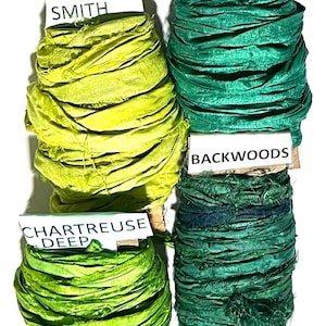 K&ouml;nnte beinhalten: Vier Spulen aus zerknittertem Seidenband in Gr&uuml;nt&ouml;nen. Die Etiketten tragen die Aufschriften Granny Smith, Ocean, Backwoods und Chartreuse Deep. Jede Spule besteht aus strukturiertem Stoff mit ausgefransten Kanten, der um einen Kern gewickelt ist.