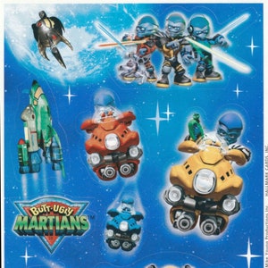 May include: A set of stickers featuring characters from the animated series "Butt-Ugly Martians". The stickers include a spaceship, a robot dog, and several alien characters in different poses.