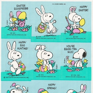 May include: A sheet of stickers featuring Snoopy dressed as an Easter bunny. The stickers feature various Easter-themed designs, including eggs, flowers, and the text "Happy Easter!" and "Happy Egg Hunting!"