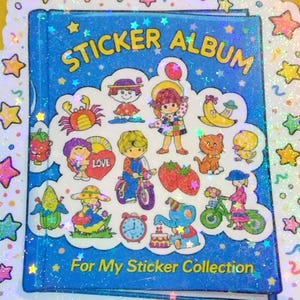 May include: A white ceramic mug with a black handle and the text "But First, Coffee" in a bold, black font. The mug is set against a neutral background, highlighting its simple design.