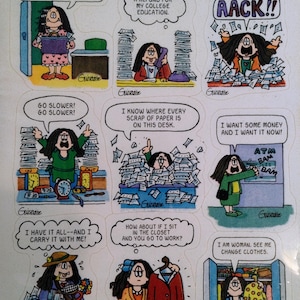 May include: A sheet of Cathy comic strip stickers. The stickers feature various scenes with the Cathy character, including her dealing with stress, money, and work. The text includes phrases like "Go slower!" and "I want some money and I want it now!"