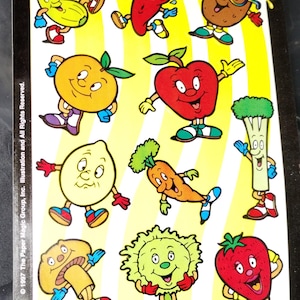 May include: A sheet of colorful stickers featuring anthropomorphic fruits and vegetables. The stickers include a smiling orange, apple, lemon, carrot, and strawberry. The packaging reads "Sticker Central THE FUN ZONE!" and "Groovy Glass 2 Sided!"