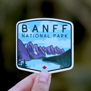 May include: A blue and white sticker with a mountain scene and the text "Banff National Park".