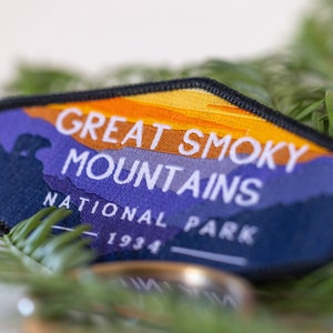 Puede incluir: Un parche bordado azul y naranja con el texto "Great Smoky Mountains National Park 1934".