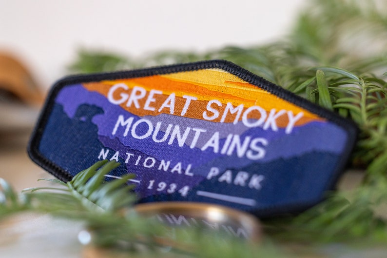 Puede incluir: Un parche bordado azul y naranja con el texto "Great Smoky Mountains National Park 1934".