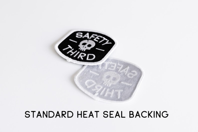 Two Safety Third patches, one flipped to show the grey heat seal backing, with text noting standard backing.