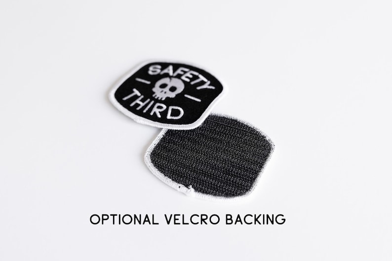 One Safety Third patch lies face up beside another turned over to reveal black loop velcro backing.