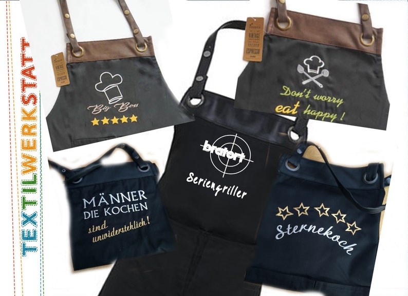 Op de afbeelding: Vijf verschillende zwarte schorten met verschillende geborduurde ontwerpen. De ontwerpen omvatten "Big Boss" met vijf sterren, "Don't worry eat happy!" met een koksmuts en gekruiste lepels, "M&auml;nner die kochen sind unwiderstehlich!" (Mannen die koken zijn onweerstaanbaar!), "bratort Seriengriller" (Grillmeester) en "Sternekoch" (Sterrenkok) met vijf sterren.