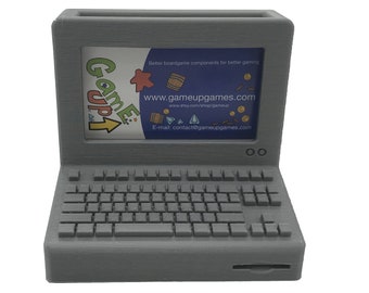 Könnte beinhalten: Ein grauer, 3D-gedruckter Desktop-Organizer in Form eines Vintage-Computers. Der Bildschirm zeigt den Text "Game Up!" und die Website "www.gameupgames.com".