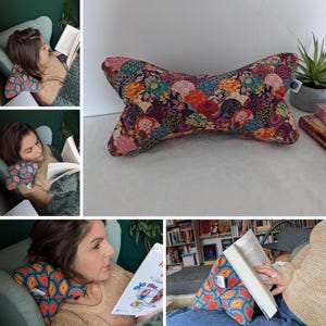 Puede incluir: Una almohada colorida y estampada con forma de hueso. La almohada está hecha de tela con un diseño floral y geométrico en tonos rojos, naranjas, amarillos, verdes, azules y morados. La almohada está tumbada sobre una superficie blanca.