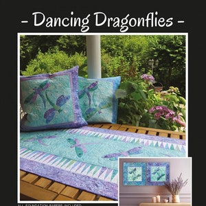 Pode incluir: Uma exibição com um edredom e duas almofadas a condizer com desenhos de libélulas em tons de azul, roxo e verde. O texto "Dancing Dragonflies" e "Jacqueline de Jonge BeColourful" também são visíveis.