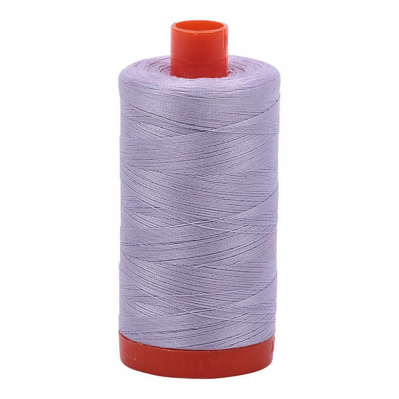 May include: A spool of lavender-colored thread with an orange plastic bobbin.