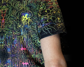 Op de afbeelding: Zwart T-shirt met een levendig, neonkleurig geometrisch ontwerp. Het patroon bevat onderling verbonden lijnen, vormen en gloeiende elementen in tinten groen, geel, blauw en roze. Het ontwerp bedekt het hele shirt en creëert een psychedelisch effect.