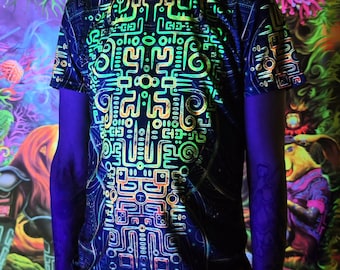 Op de afbeelding: Zwart T-shirt met een neon groen, oranje en geel geometrisch ontwerp. Het ontwerp gloeit onder UV-licht. Het shirt heeft een ronde hals en korte mouwen. De woorden "UV-active" staan rechtsonder gedrukt.