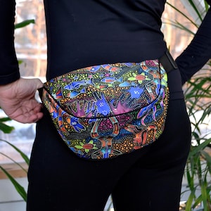 Może przedstawiać: Kolorowa nerka z czarnym paskiem. Nerka ma żywy wzór z rybami, ptakami i innymi zwierzętami na czarnym tle.