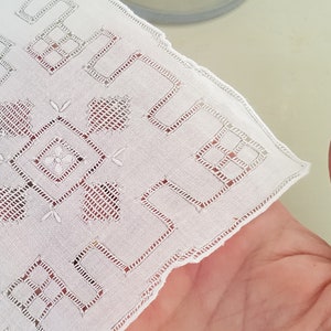Può includere: Fazzoletto di cotone bianco con un delicato ricamo di forme geometriche e motivi floreali.