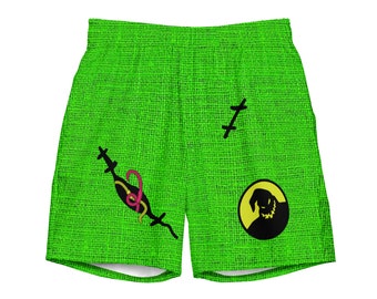 Puede incluir: Shorts verdes con un gráfico en blanco y negro de un personaje de la película "Pesadilla antes de Navidad". El personaje lleva un sombrero y tiene la boca cosida. Los pantalones cortos también tienen un gráfico de serpiente rosa y verde.