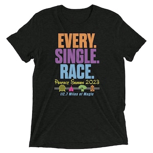 Puede incluir: Camiseta negra con el texto "EVERY. SINGLE. RACE." en naranja, morado y azul. Debajo, "Perfect Season 2023" y la frase "112.7 Miles of Magic" con iconos de monumentos.