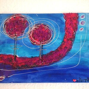 May include: Abstract painting on canvas with two pink trees and a pink swirl on a blue background. The painting is signed "Love Purple".