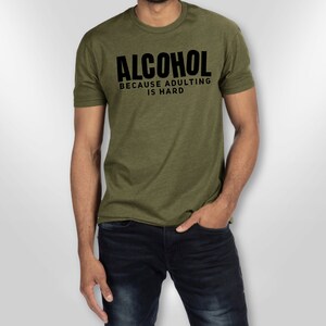 May include: A green t-shirt with black text that reads "ALCOHOL BECAUSE ADULTING IS HARD".